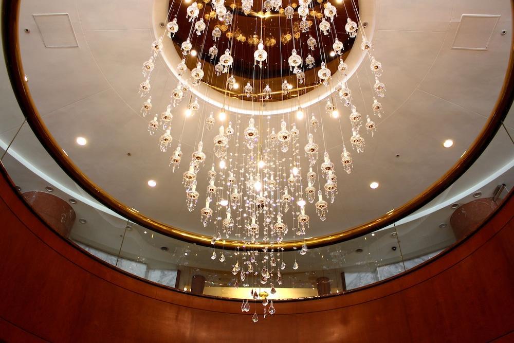 Evergreen Laurel Hotel - Тайчжун Экстерьер фото The photo shows an elegant chandelier hanging from a ceiling. The chandelier features numerous hanging crystals that reflect light, creating a sparkling effect. The ceiling itself is circular and designed with a smooth surface, accented by a circular