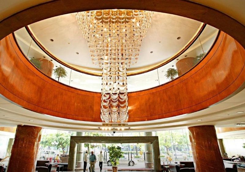 Evergreen Laurel Hotel - Тайчжун Экстерьер фото The photo shows the interior of a lobby, featuring a large, elegant chandelier hanging from a circular ceiling. The design incorporates warm wooden tones and modern architectural elements. The space is open and airy, with large glass windows allowing