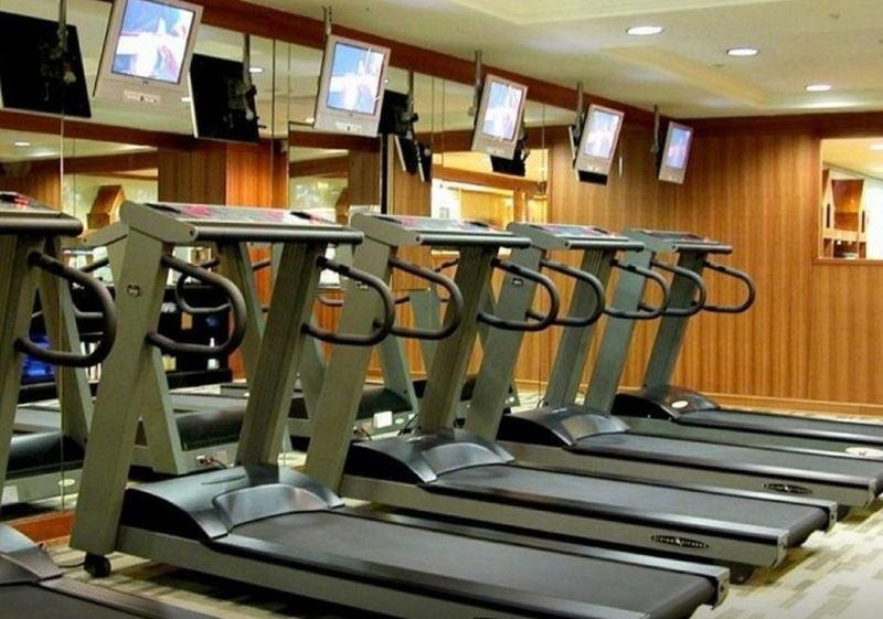 Evergreen Laurel Hotel - Тайчжун Экстерьер фото The photo shows a fitness area with several treadmills lined up in front of a wall of mirrors. Each treadmill is equipped with a console and has screens above them, likely displaying workout information or entertainment. The interior has a modern des