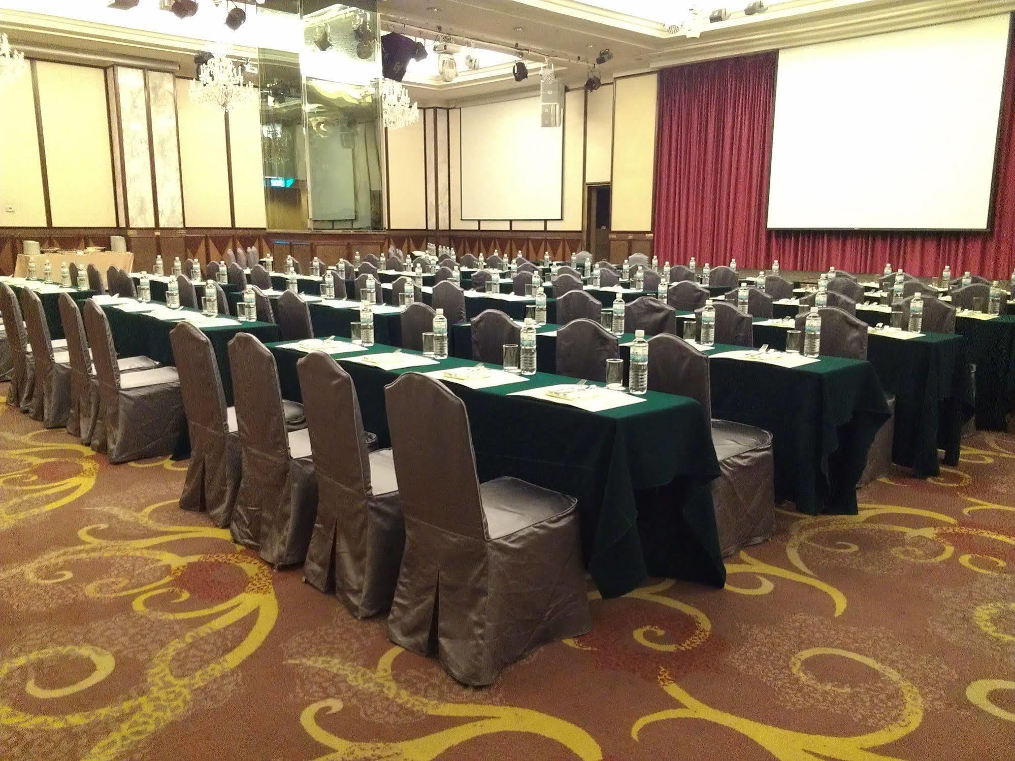 Evergreen Laurel Hotel - Тайчжун Экстерьер фото The photo shows a large conference or meeting room set up with multiple tables arranged in a structured manner. Each table is covered with a tablecloth, alternating between black and green. There are chairs around each table, and each place setting a