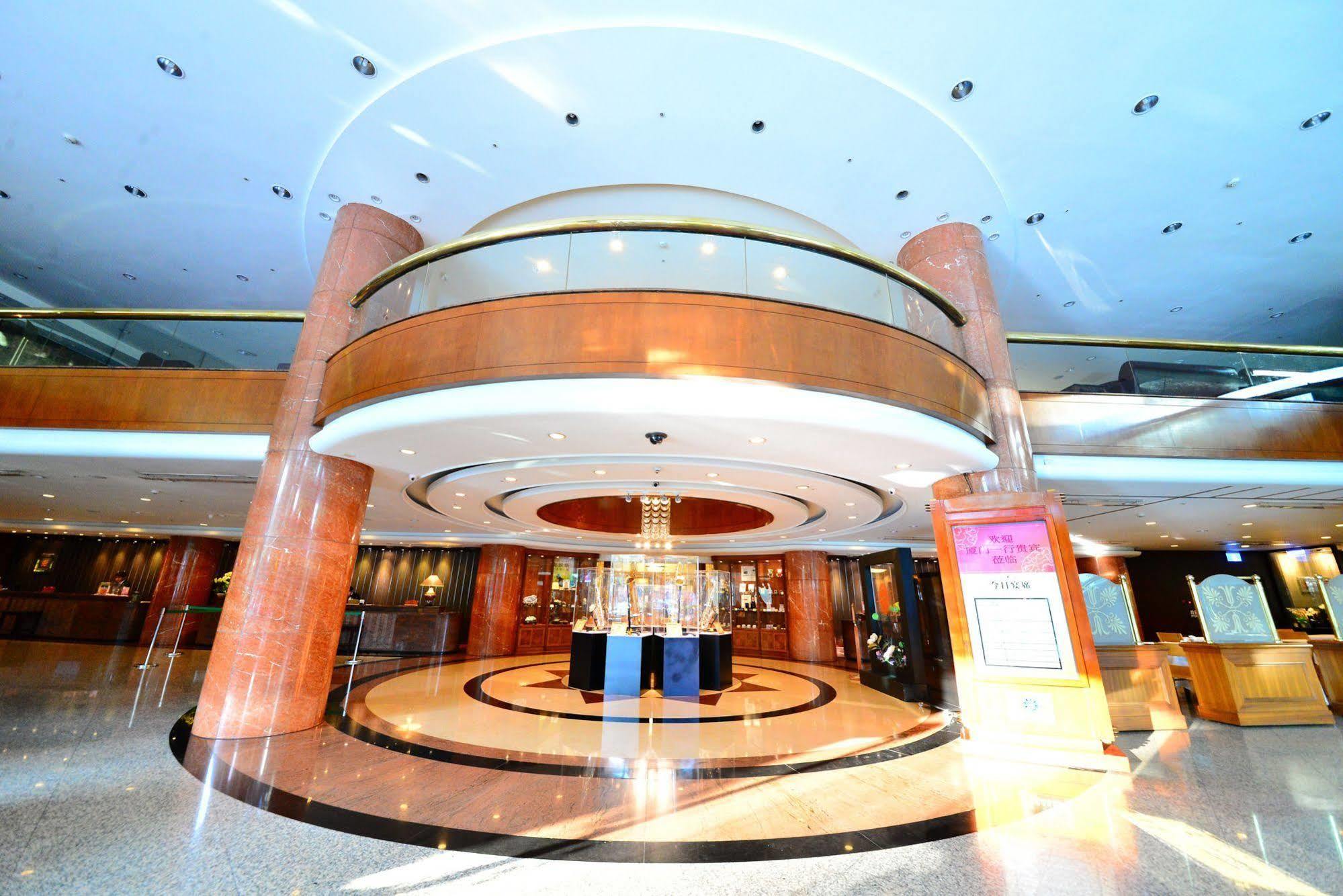 Evergreen Laurel Hotel - Тайчжун Экстерьер фото The photo shows the interior of a spacious lobby area. It features a modern architectural design with polished surfaces and a circular ceiling structure. The walls are accented with wooden panels, and there is a central chandelier hanging from the ce