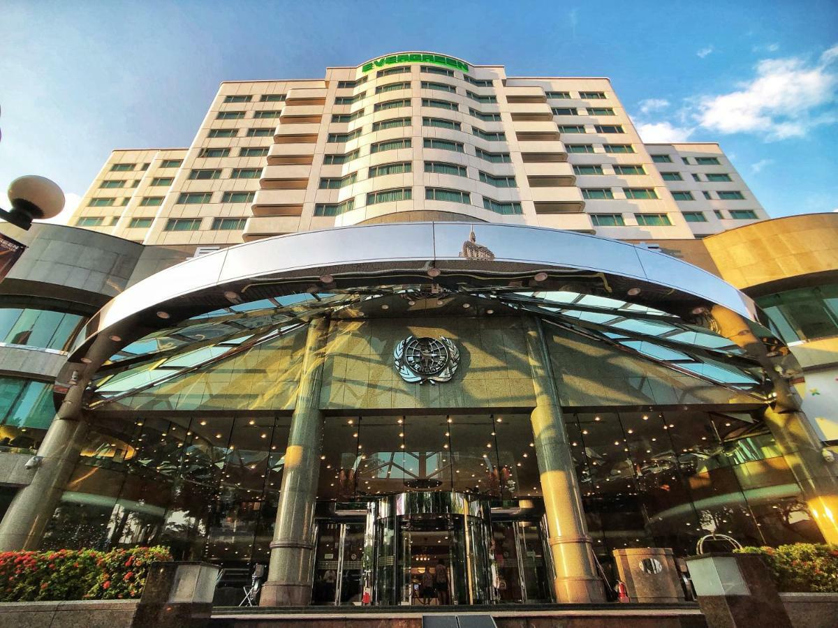 Evergreen Laurel Hotel - Тайчжун Экстерьер фото The photo shows the exterior of a modern hotel building. The entrance features a large, glass canopy supported by columns, creating a welcoming area. The facade of the hotel is composed of a mix of glass and concrete, with large windows that suggest 