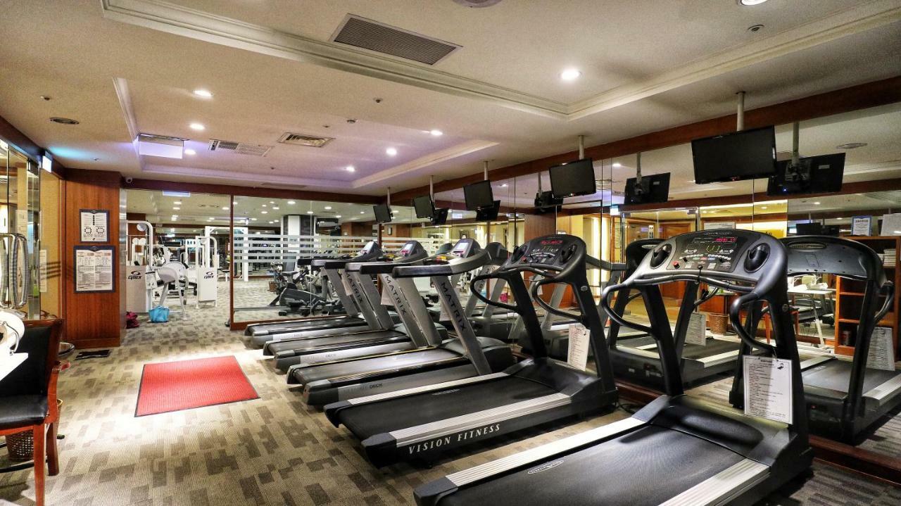Evergreen Laurel Hotel - Тайчжун Экстерьер фото The photo shows a gym environment featuring several treadmills lined up in a row. The space has a bright and modern design with adequate lighting. In the background, various exercise machines and weights are visible, suggesting a well-equipped workou