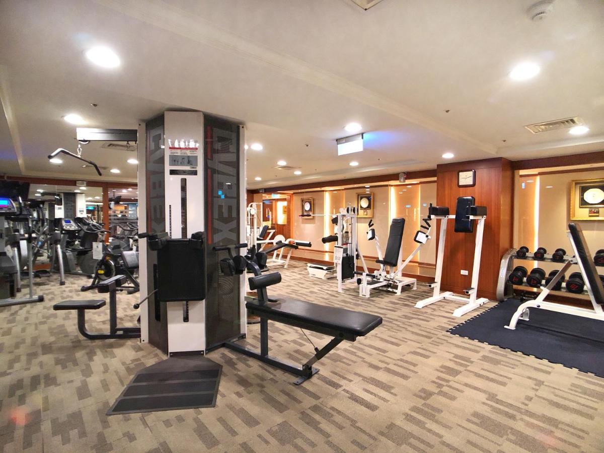 Evergreen Laurel Hotel - Тайчжун Экстерьер фото The photo shows an indoor gym or fitness area. It features various workout equipment, including:

- A multi-station gym machine in the center for strength training.
- Weight benches and free weights organized on shelves.
- Cardio equipment, likely tr